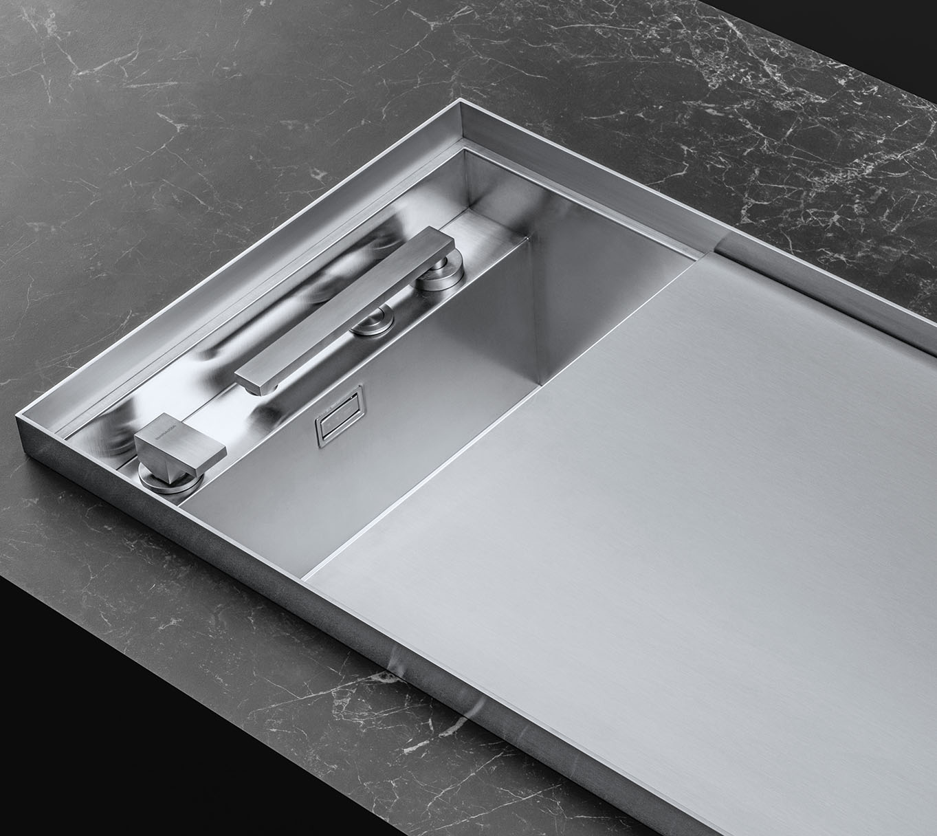 Dettaglio di un lavello in acciaio inox con coperchio semi-chiuso, rubinetto miscelatore abbattibili e il suo comando