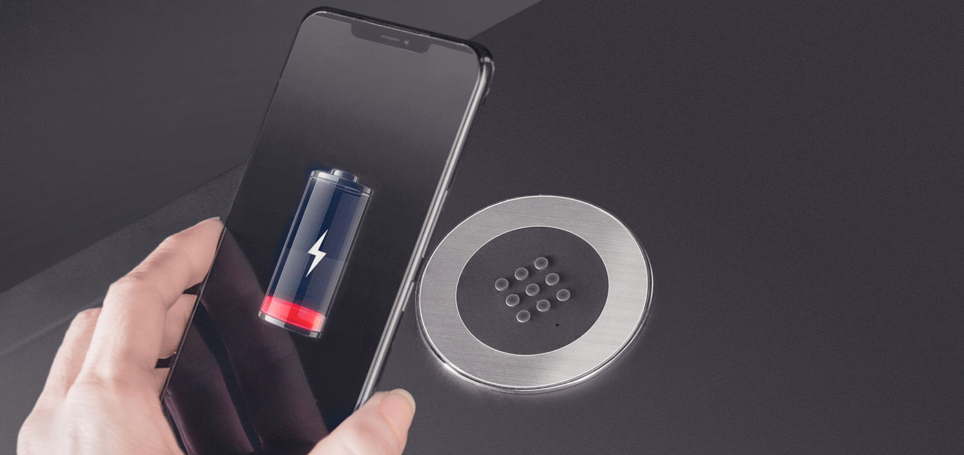 Smartphone con batteria scarica che sta per essere poggiato su caricabatterie a induzione e incasso in acciaio inox