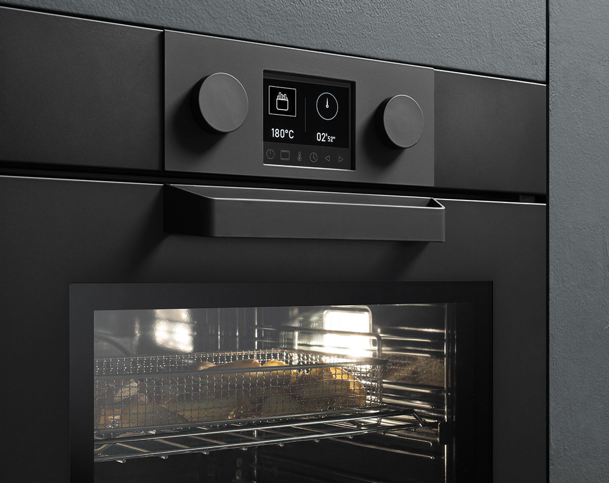 Forno a microonde a incasso nero con finitura satinata, con una teglia contenente delle patate