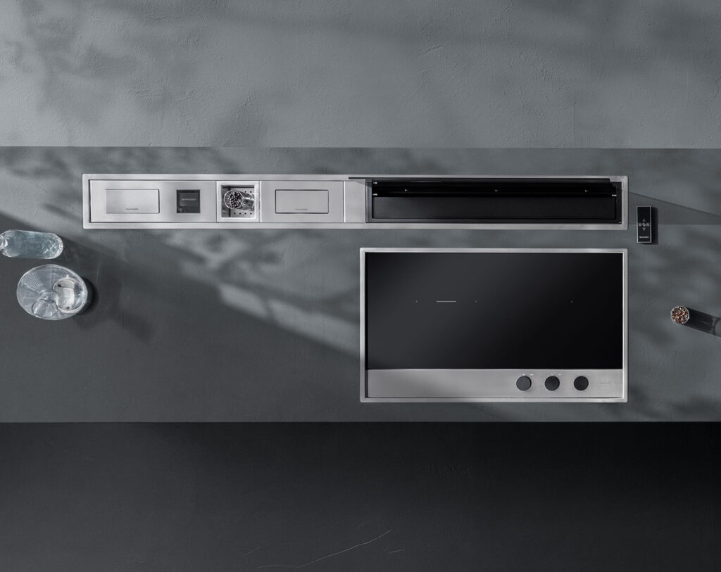 Canale attrezzato composto da: piano cottura a induzione e incasso, bilancia in acciaio inox a incasso, vaschetta cieca con fondo in acciaio inox, portaprese basculante in acciaio inox e Cappa aspirante per canale