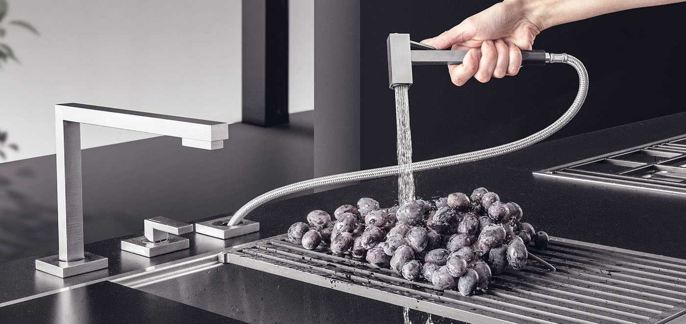 Doccino estraibile in acciaio inox appartenente ad un set di tre elementi viene utilizzato per lavare un grappolo d'uva poggiato su una griglia di scolo
