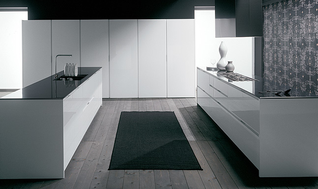 Vista di una cucina composta da due piani, posti parallelamente uno di fronte all'altro, su cui rispettivamente poggiano un piano cottura e un lavello affiancato da stoviglie