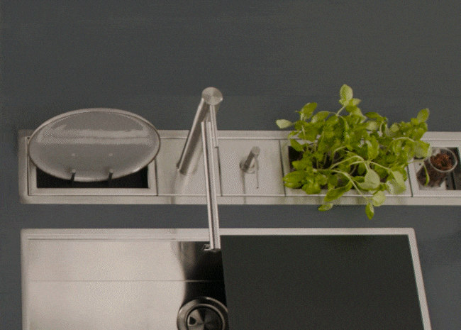 Panoramica dall'altro di un canale attrezzato in acciaio inox, posizionato sopra a un lavello, e i suoi vari accessori.