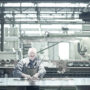 Un operaio in linea di produzione lavora su un piano cottura in costruzione.